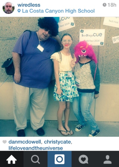Photo of Urbie and two women against a San Diego CUE backgrop